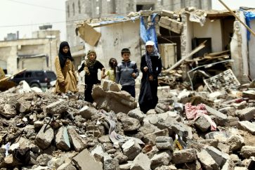Varios niños juegan junto a una casa destruida por la aviación saudí en Yemen