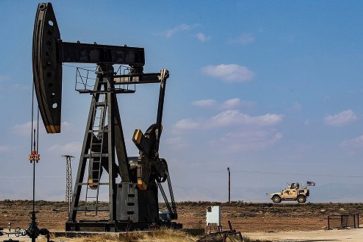Vehículo estadounidense pasa cerca de un poco de petróleo en Siria