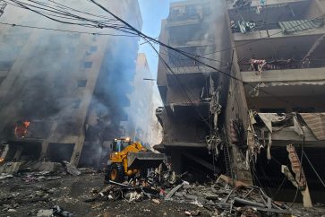 Una excavadora limpia los escombros frente a los edificios afectados por un ataque aéreo israelí que tuvo como objetivo el barrio de Haret Hreik, en los suburbios del sur de Beirut, el 21 de noviembre de 2024, en medio de la guerra en curso entre Israel y Hezbolá. (Foto de AFP)